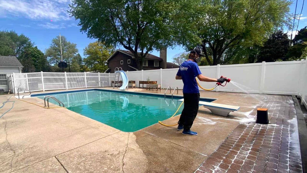 Pressure washing a pool deck at a Miami home